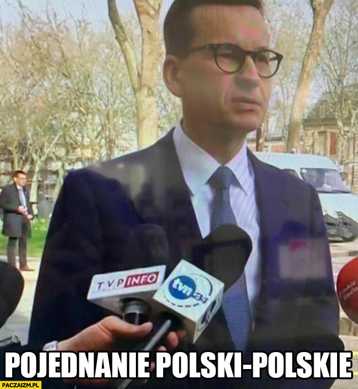 Jedna ręka trzyma mikrofon TVP info i TVN 24 pojednanie polsko-polskie